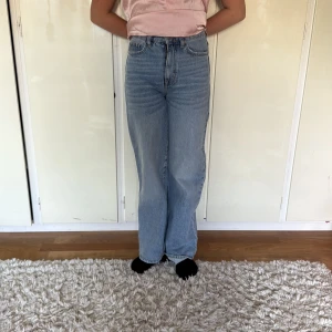  ljusblå jeans high waist - Ljusblå  jeans med hög midja och raka ben. Klassisk femficksmodell i jeansmaterial . Snygg vintage vibe och passar perfekt till en avslappnad stil.
