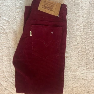 Vintage vinröda levis jeans - Ett par sällsynta vintage supercoola jeans i vinröd färg med manchester material som kommer tillbaka nu! Skulle däremot säga att de är lite mindre i storleken, runt W24/25