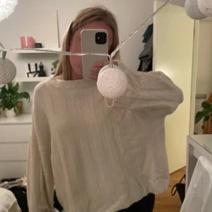 Vit stickad tröja från Gina Tricot - Supermjuk och oversized vit stickad tröja från Gina Tricot. Tröjan har diskreta lodräta ränder, bred halsringning och långa ärmar. Perfekt för lager-på-lager och chill dagar. Enkel att matcha med både jeans och kjol.