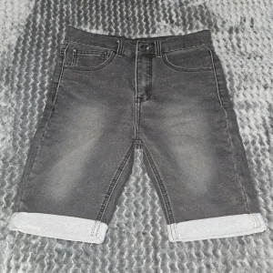 Grå jeansshorts från HAILYS - Snygga grå jeansshorts från HAILYS med klassisk femficksdesign och uppvikta benslut. Shortsen har en normal passform och midwaist, tillverkade i slitstarkt jeanstyg med lätt tvättad look. Perfekta för chill dagar under sommaren.