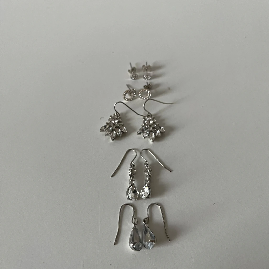 Set med fem par silvriga örhängen