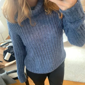 Blå ribbad polotröja från NA-KD - Mysig blå polotröja från NA-KD i storlek S. Tröjan är ribbstickad med lång ärm och har en hög krage.💕☺️