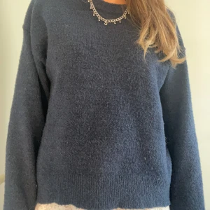 Mörkblå stickad tröja - Mysig mörkblå stickad tröja från Gina Tricot med rund hals och långa ärmar. Tröjan har en enkel, klassisk design med ribbade muddar vid hals, ärmslut och nederkant. Perfekt för att hålla sig varm under kyliga dagar. Strl 150-164 men passar xs/s 🥹❣️