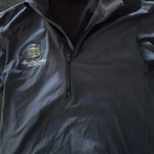 Mörkblå half zip tröja J.Lindeberg - Snygg mörkblå långärmad tröja från J.Lindeberg med half zip och broderad Boo Hof Slott Golf Club-logga på bröstet. Tröjan har ett otroligt skönt material för golf. Säljer den för den är för liten, köpt på bro hof för 1699 kronor och mitt pris är 799, men kan såklart diskuteras!!!