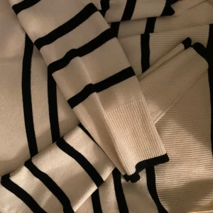 Randig stickad tröja från Vero Moda - Säljer en oversized stickad tröja från Vero Moda i storlek XS. Tröjan är vit med svarta horisontella ränder, har lång ärm och ribbade muddar. Pris kan alltid diskuteras vid snabb affär!💕