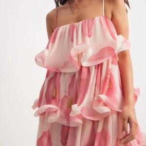 Blommig volangklänning med tunna axelband - Superfin kortklänning med volanger och tunna axelband. Från NAKD, aldrig använd 