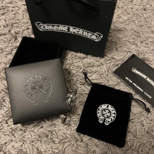 SILVER ARMBAND MED KORS - Hej säljer detta armaband med öppet avslut och pryds av deras klassiska korsdetaljer. Kommer med original ask, påse och putsduk. Perfekt för dig som vill ha en edgy och stilren accessoar.