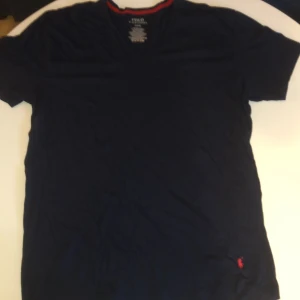 Marinblå v-ringad t-shirt Polo Ralph Lauren - Snygg marinblå t-shirt från polo Ralph louren, v- ringad t-shirt som man kan ha på chill dagar. Klassisk passform och korta ärmar.