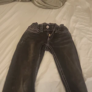 Svarta jeansbyxor från Gina Tricot - Säljer ett par svarta jeansbyxor från Gina Tricot i storlek 146. Byxorna har vita kontrastsömmar, resår i midjan och klassiska fickor både fram och bak med snygga detaljer. Jätte sköna