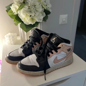 Nike Air Jordan 1 Mid svart/rosa/vit - Snygga Nike Air Jordan 1 Mid sneakers i svart, vitt och ljusrosa med klassisk Jordan-logga på sidan🤍🩷