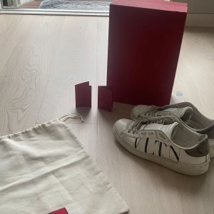 Valentino opens i vit -   👟✨ Valentino Garavani VLTN Sneakers – Stil och Klass i Varje Steg! ✨👟  Unna dig ett par ikoniska Valentino Garavani sneakers med den trendiga "VLTN"-märkningen. Dessa skönheter i storlek 37,5 (37 1/2) är inte bara skor, de är en fashion statement!  👟 Skick: Ganska bra, har några slitningar !  🎁 Kommer med: Självklart ingår både dustbag och box  100% ÄKTA