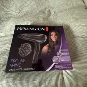 Remington Pro-Air Shine hårfön - Remington Pro-Air Shine hårfön med 2300 watt effekt och svart design. Medföljer en diffuser och stylingmunstycke. Perfekt för att få glansigt och frizzfritt hår snabbt. Ergonomiskt handtag och flera värme- och hastighetsinställningar. Funkar jätte bra för lockigt hår, helt ny aldrig använt. Nyförpacknig.
