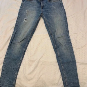 Ljusblå skinny jeans från Zara Basic - Säljer ett par ljusblå jeans från Zara Basic 1975 Denim. Jeansen har slitna detaljer på låret, klassisk femficksmodell och smal passform. Använda men i bra kvalitet. Skriv vid frågor och funderingar, pris kan diskuteras!💕💕