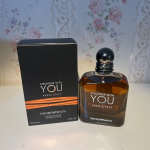 Emporio Armani Stronger With You - Emporio Armani Stronger With You Absolutely är en herrparfym i en stilren, fyrkantig glasflaska med mörk bärnstensfärgad vätska och silverfärgad rund kork. Förpackningen är svart med orange detaljer och rymmer 100 ml eau de parfum.