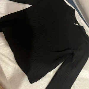 Svart ribbad långärmad tröja DIVIDED XS - Säljer en svart långärmad tröja från DIVIDED i storlek XS. Tröjan har ett ribbat mönster som ger en snygg struktur och är tillverkad i ett mjukt material. Perfekt till lager-på-lager eller som basplagg i garderoben.