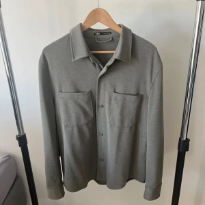 Overshirt Ljusgrön - En helt ny ljusgrön overshirt från Zara. 10/10 skick, jag köpte den förra året för 500kr, men jag har använt den 3-4 gånger. Den har inga skador eller liknande. Den är helt ny kan man säga. Väldigt bekväm, man kan ha t shirt under men även hoodie. Det är storlek M, och den sitter även som ett M plagg. Dessa säljs inte mer. Rekommenderar starkt!