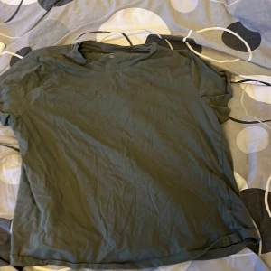 Olivgrön t-shirt från VRS Basis - Enkel olivgrön t-shirt från VRS Basis i storlek XXL. T-shirten har klassisk rund hals och korta ärmar, perfekt för en avslappnad stil. Tillverkad i mjuk bomull som känns skön mot huden.