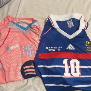 Barça & Frankrike fotbollströjor #10 - Två feta fotbollströjor: en rosa Barcelona-tröja med Lamine Yamal och Nike-logga, samt en blå Frankrike VM 98-tröja med Zidane och Adidas. Båda har nummer 10 på ryggen, coola detaljer och snygga ränder. Perfekt för dig som älskar fotboll och vill sticka ut på planen.  Paketstorlek: via konversation 
