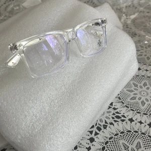 Transparenta Chrome hearts glasögon - Snygga glasögon med transparent båge och rektangulär form. Bågarna har coola silverdetaljer och små blommönster på skalmarna. Perfekt för dig som vill sticka ut med en modern och stilren look. Mvh ItsForfits 🌟