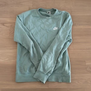 Ljusgrön sweatshirt från Nike - Säljer en ljusgrön sweatshirt från Nike i storlek XS. Tröjan har rund halsringning, långa ärmar och en broderad Nike-logga på bröstet. Jag är 187 cm och den är kort på mig. En del av tyget i vänstra armen har gått up (Bild 4) annars bra skick med märkbara men inte stora tecken på användning 
