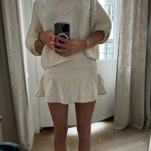 Beige volangkjol i linne - Säljer en superfin beige kortkjol i linne med volang nertill, med shorts inuti. Från stradivarius. Storlek 34, passar perfekt på mig med midje mått på ca 31 cm.