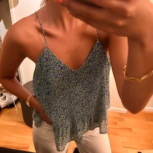 Blågrön blus med tunna axelband - Säljer en blågrön blus med tunna axelband och v-ringning. Toppen har en lös passform. Super skön! Materialet är lätt och luftigt, vilket gör den skön att bära ☀️☀️🥰använts endast en gång 