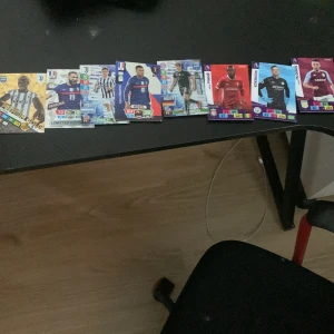 Samling av fotbollskort med kända spelare - Säljer en samling fotbollskort med spelare som Paul Pogba, Karim Benzema, Paulo Dybala, Kylian Mbappé, Thomas Müller, Sadio Mané, Ederson och Tyrone Mings. Korten har färgstarka designer och visar spelarna i sina landslags- eller klubbtröjor. Perfekt för samlare eller fotbollsintresserade.