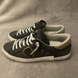 Philippe Model  - Philippe Model skor i grå och vit som ni kan se är de skadade på hälarna och lite slutage på sulorna annars i gott skick😁Säljes snabbt gärna. Storlek 42. Pris är inte hugget i sten.
