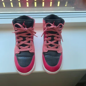 Nike Air Jordans i rosa och svart - Säljer ett par Nike Air Jordans med rosa och svarta paneler, vita detaljer och rosa snörning, i skick som nya använt endast 1 gång. 