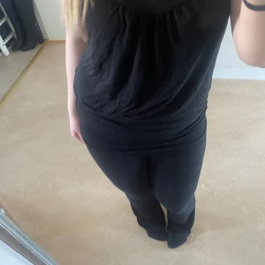 Svart linne med urringat - Urringat linne med detalj. Mjukt material och den e skön att ha på sig. 