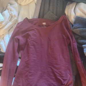 Vinröd långärmad topp från 157 - Säljer en vinröd långärmad topp från 157 med rund halsringning. Enkel och stilren modell i mjukt bomullsmaterial, perfekt att matcha med jeans eller kjol.