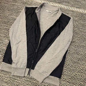 Cardigan - Riktift fet cardigan från Mango, perfekt nu under våren och till sommaren. Den är mörkblå / grå och har dubbel zip😀 Fnt skick, storlek M men passar S.  Skriv vid minsta intresse, pris kan absolut diskuteras vid smidig affär 😀