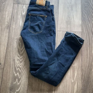 Mörkblå jeansbyxor - Tjena, säljer nu dessa snygga och välbehållna nudie Jeans i modellen Grim Tim. Använd fåtal gånger och skick i 9/10. Storleken är W29 L32