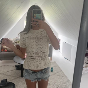Vit stickad topp från Zara - Supersöt vit stickad topp från Zara med korta ärmar och snyggt hålmönster. Tröjan har rund halsringning och är lätt transparent, perfekt till sommaren. Skön och luftig med en trendig vibe, passar till både jeans och kjol.