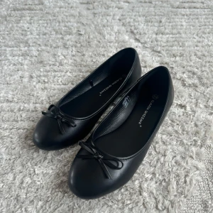 Svarta ballerinaskor med rosett - Säljer dessa fina basic ballerina skor då dem inte passade mig. Helt oanvända. Storlek 39.