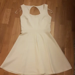 Ivory kort klänning Sweet Storm M - Supersöt kort klänning i ivory från Sweet Storm. Klänningen har ärmlös design, rund halsringning och en snygg cut-out detalj i ryggen. Kjolen är utställd och ger en riktigt fin siluett. Perfekt för dig som gillar stilrena och ljusa plagg. PRIS KAN DISKUTERAS!