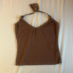 Brun halterneck linnetopp Bubbleroom XS - Säljer en brun halterneck linnetopp från Bubbleroom i storlek XS. Toppen har smala axelband som knyts i nacken och en lätt v-ringad urringning. Mjuk och stretchig bomullskänsla, perfekt till sommaren. Enkel och stilren design som är lätt att matcha. Nypris 69 kr.