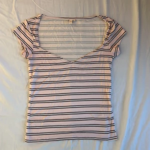 Randig topp med v-ringning från Nelly - Säljer en vit och svart randig topp från Nelly i storlek S. Toppen har v-ringning, korta ärmar och en figurnära passform. Perfekt för dig som gillar en enkel men snygg stil. Materialet känns mjukt och stretchigt. Nypris 199 kr.