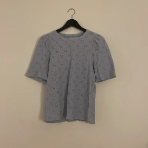 Söt topp från Vila! - Skriv innan köp! Supersöt ljusblå blus från Vila med korta ärmar och broderade detaljer i ett blommigt mönster. Blusen har rund halsringning och är gjord i ett lätt bomullstyg som känns luftigt och fräscht. Perfekt för vår och sommar när du vill ha något extra fint.💕Den är i ny skick bara ingen lapp kvar 😊Pris kan diskuteras 