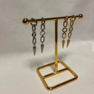 Chunky kedjeörhängen med spikes - Säljer två par statement örhängen med kedjor och spetsiga spikes. Ena paret är i silverfärg och det andra i guld, båda med coola länkar och hängande konformade detaljer. Perfekta för dig som vill sticka ut med en edgy vibe.