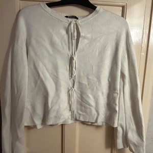 Vit kofta med snörning från Gina Tricot - Superfin vit kofta från Gina Tricot med snörning framtill. Långärmad och i mjukt stickat material, perfekt för lager på lager. Enkel och stilren design som passar till många outfits. Använd några gånger