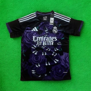 Real Madrid x Adidas svart/lila tröja S - Snygg Real Madrid fotbollströja från Adidas i svart och mörklila med coolt ormmotiv och rosor på framsidan. Klassiska vita Adidas-ränder på axlarna och klubbmärke på bröstet. Tillverkad i lätt och ventilerande material, perfekt för match eller träning.
