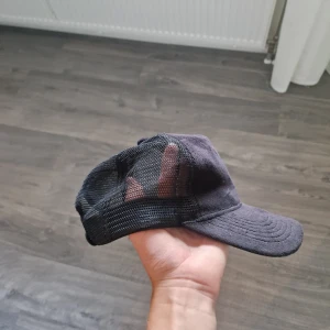 Svart truckerkeps från Maggiore - Svart truckerkeps från Maggiore med klassisk böjd skärm och mesh-paneler på sidorna och bak för extra ventilation. Justerbar snapback baktill för perfekt passform. Snygg och enkel design som funkar till det mesta.
