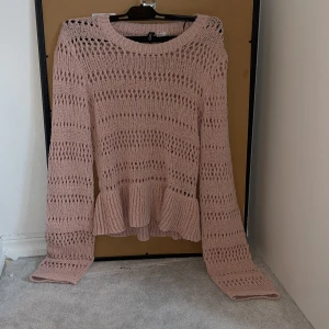 Rosa stickad volangtröja H&M Divided XS - Supersöt ljusrosa stickad tröja från H&M  Divided i storlek XS. Tröjan har lång ärm, hålstickat mönster och en volangdetalj nedtill som ger en extra touch. Perfekt för dig som gillar en feminin och trendig stil. Vill tillägga att tröjan är oanvänd, men klippte av lappen då jag trodde jag skulle använda den.
