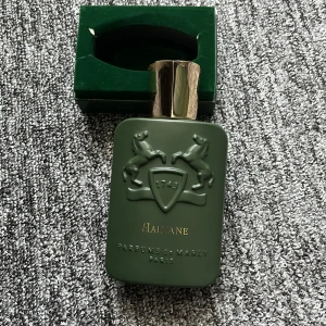 Parfums de Marly Haltane 125ml - Lyxig parfym Haltane från Parfums de Marly i en mörkgrön, matt flaska med guldfärgat lock och upphöjt emblem med två hästar. Kommer i elegant grön box med gulddetaljer. Flaskan rymmer 125 ml och har exklusiv känsla.