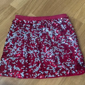 paljettkjol - Glittrig rosa kortkjol från Lindex Kids, täckt med massor av paljetter som reflekterar ljuset snyggt. Resår i midjan för skön passform. Perfekt för dig som vill sticka ut och glänsa extra mycket.