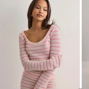 Rosa och vit randig långärmad tröja - Superfin tröja  med rosa och vita ränder. Tröjan är stickad, har lång ärm och en snygg rundad urringning. Den är figurnära och har en mjuk, cozy känsla – perfekt för dig som gillar en söt och chill stil.