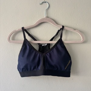 Mörkblå sporttopp från Newbody - Sport-bh med vaddering som går att plocka ur. Lapp bortklippt så kan ej med säkerhet säga om det är XS eller S, men något av det iaf. Axelband justerbara.