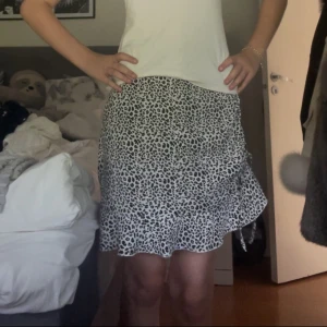 Leopardmönstrad kortkjol med volang🤍 - Snygg kortkjol med svartvitt leopardmönster och volang nertill. Kjolen har en liten snörningsdetalj på sidan som ger en extra touch!Materialet känns lätt och är knappt använd. Den är ursprungligen från chien men jag köpte på sellpy💓