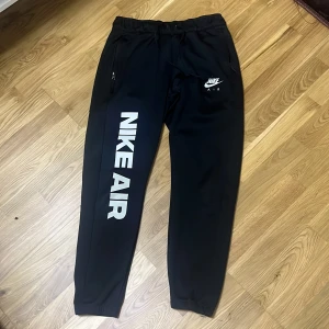 Svarta Nike Air mjukisbyxor M - Säljer svarta mjukisbyxor från Nike Air med stor vit logga längs ena benet och mindre logga på höften. Säljer den för den är mindre än mig och har knappt använts. Pris kan alltid diskuteras!